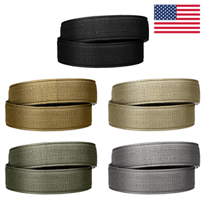 A collection of Kore Essentials USA-made tactical gun belt straps. Visible are five gun belt straps: black, coyote, ranger green, tan 499 and gray.